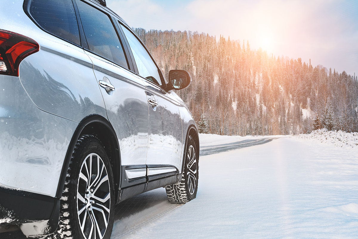 Chevy vehicle driving through snowy winter conditions near Imlay City, MI, highlighting the importance of winter car preparation for safe Michigan driving